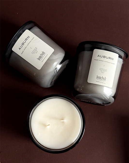Three fall candles with 'Auburn' branding on a dark background